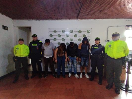 Personas capturadas-policías custodiando