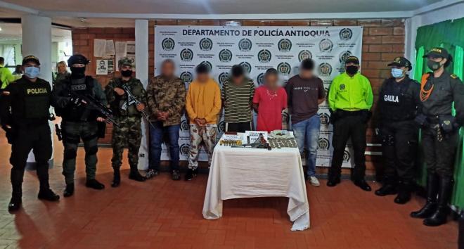 Personas capturadas-policías custodiando 