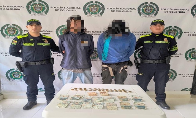 Dos capturados y dos polic&iacute;as uno a la derecha y otro a la izquierda de ellos