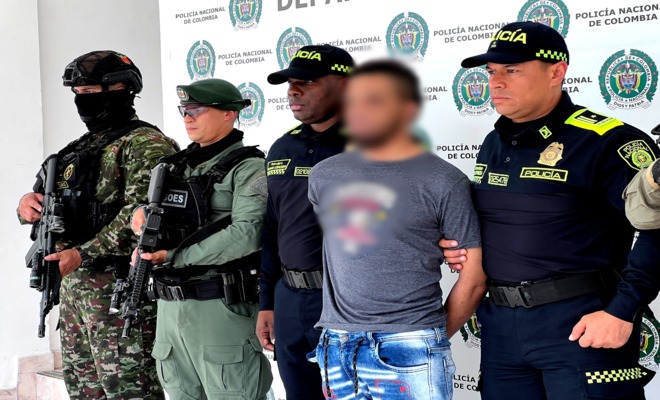 Dos soldados, un policía del GOES y dos policías custodian a un capturado