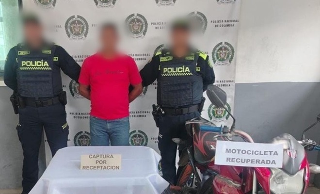 Dos funcionarios policiales una persona capturada y una motocicleta recuperada