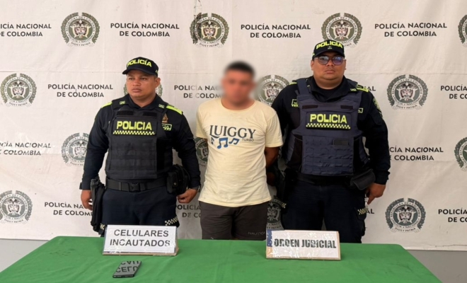 Dos policías custodian a un hombre capturado por presunto homicidio