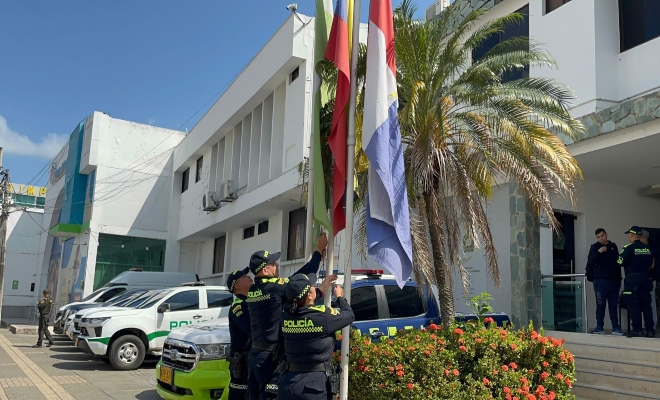 Tres polic&iacute;as izando la bandera 