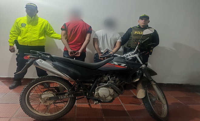 Dos capturados con motocicleta incautada y dos policías uniformados