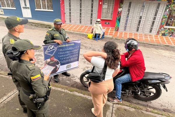Tres polic&iacute;as haciendo cama&ntilde;as de prevenci&oacute;n frente a una persona en su motocicleta y una ciudadana 