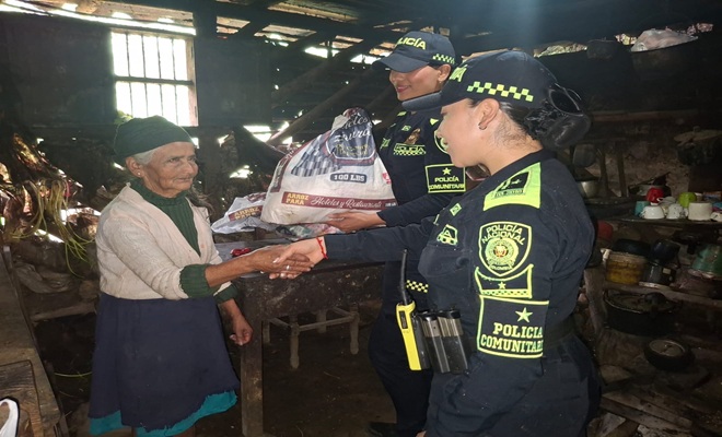 Tres personas a la derecha dos mujeres policías, y a la izquierda una mujer campesina 