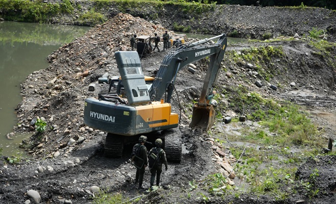 Polic&iacute;as junto una excavadora