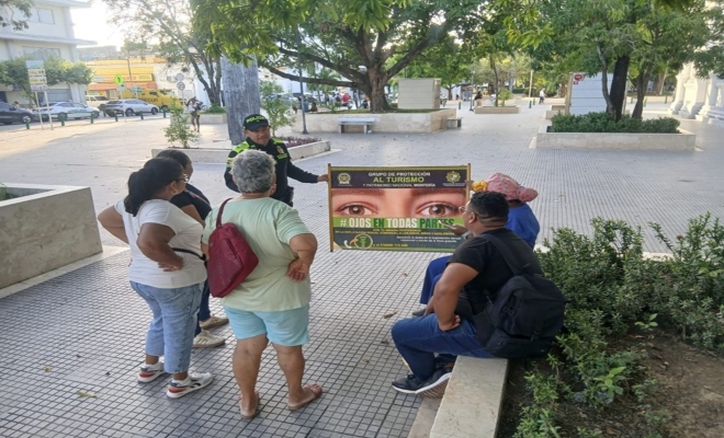 Un policía realizando charla a cinco ciudadanos 