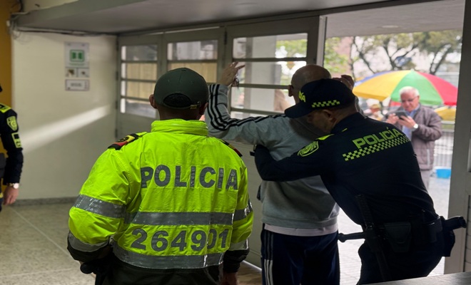 Dos policías realizando registro a persona en los puntos de votación