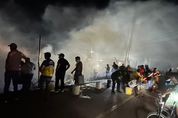 Policía llevando agua para apagar el incendio