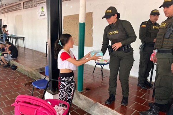 Policías entregando elementos de aseo a las personas