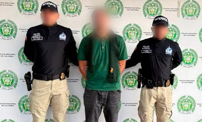 Dos funcionarios de Interpol sostienen a ciudadano franc&eacute;s retenido