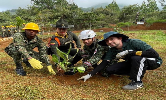 Un grupo de Policia Carabineros, un soldado, funcionario de la comunidad siembran un árbol  
