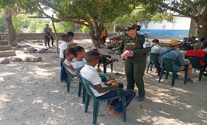 Un policía entregando dulces a los niños, niñas y adolescentes