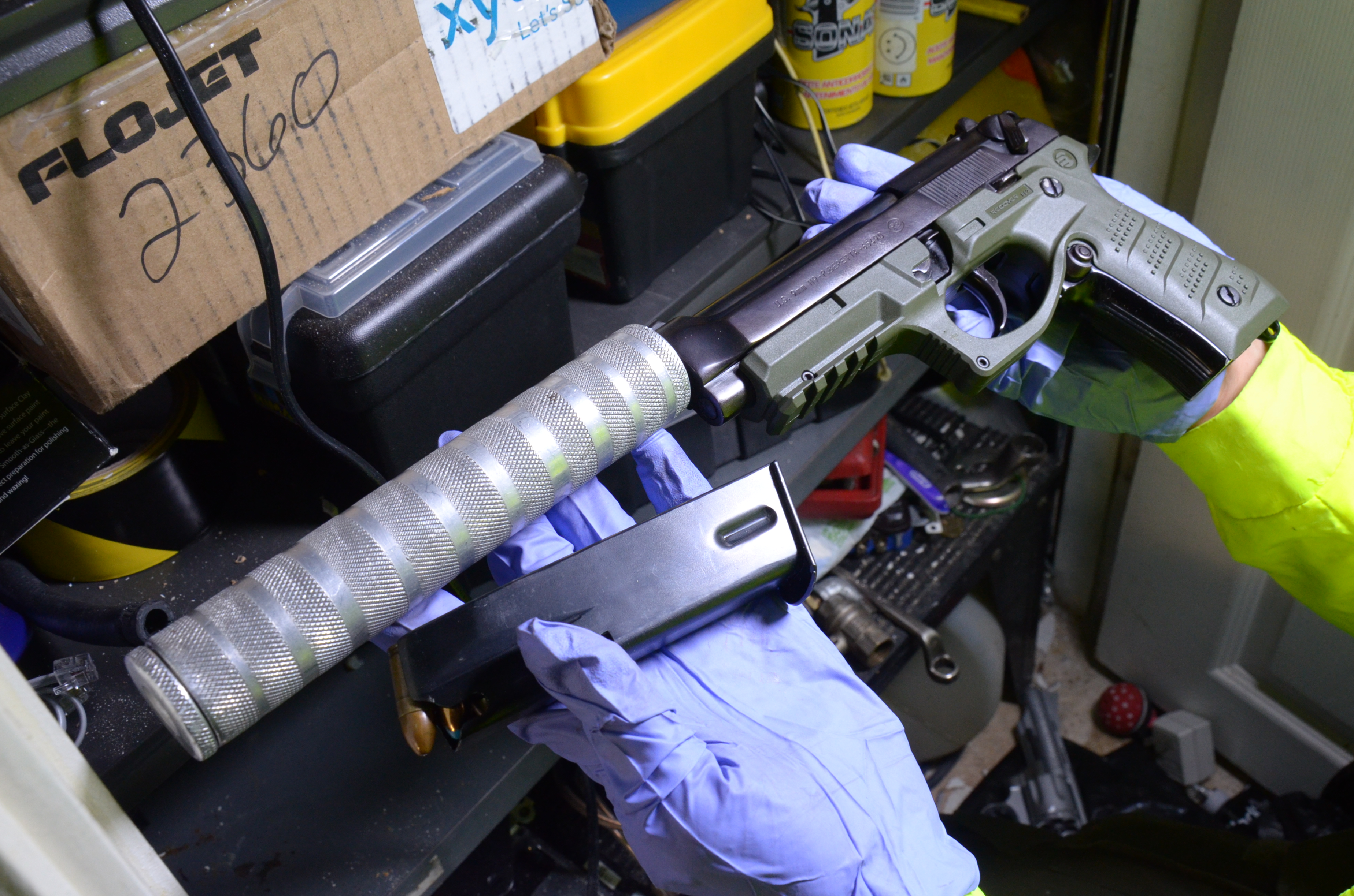 Policía con arma de fuego con silenciador en sus manos