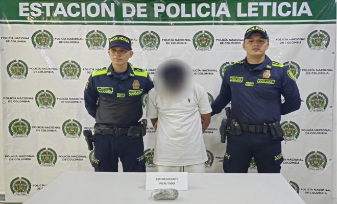 Dos policías, una persona capturada y encima de una mesa estupefacientes incautados