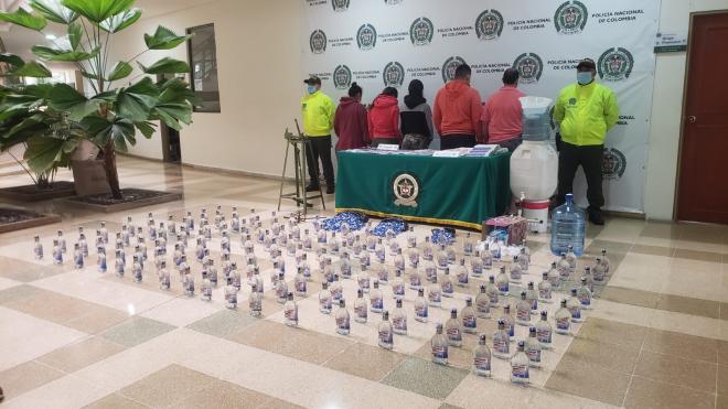 5 personas capturadas-policías custodiando-licor adulterado incautado