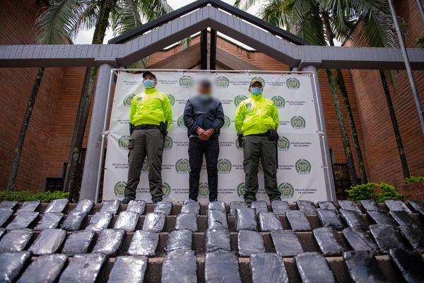 Policías custodian a un capturado con 200 kilos de marihuana en Medellín