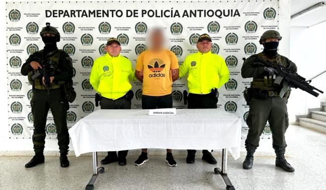 Personas capturadas-policías custodiando