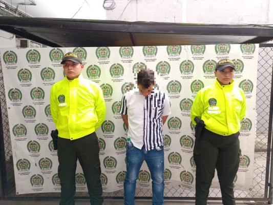 Persona capturada-policías custodiando