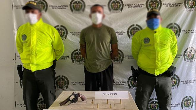 una persona capturada-policías custodiando-arma de fuego y munición 