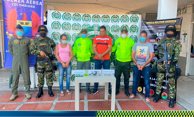 tres personas capturadas-policías custodiando-arma de fuego y munición incautada