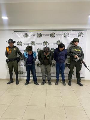 Personas capturadas-policías custodiando