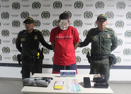 foto de dos policías con una persona capturada y elementos recuperados