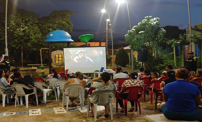 comunidad de barrio El Balboa viendo una pelicula en le parque principal del barrio 