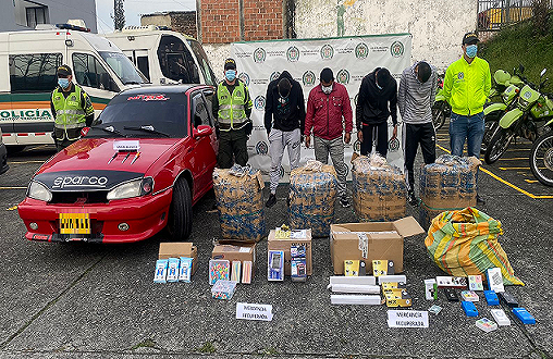 cuatro personas capturadas-policías custodiando-mercancía incautada-vehículo inmovilizado