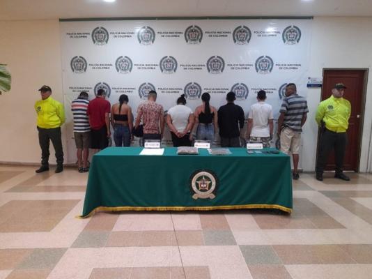 Personas capturadas-policías custodiando