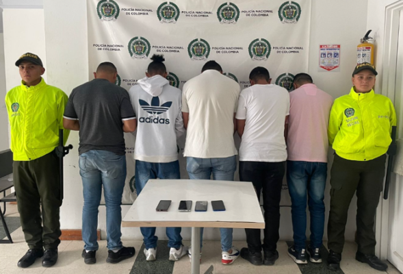 Personas capturadas-policías custodiando