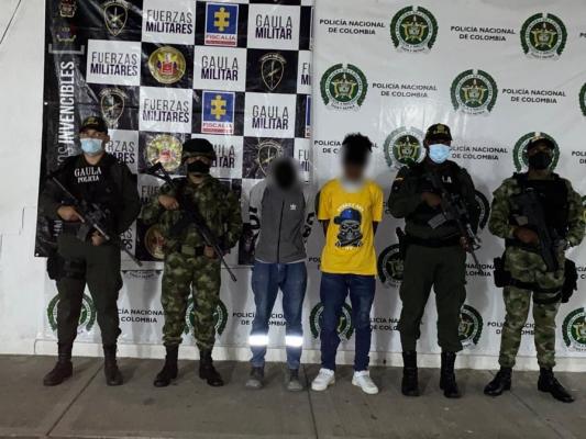 2 personas capturadas-policías custodiando