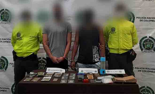 dos personas capturadas-policías custodiando-elementos incautados