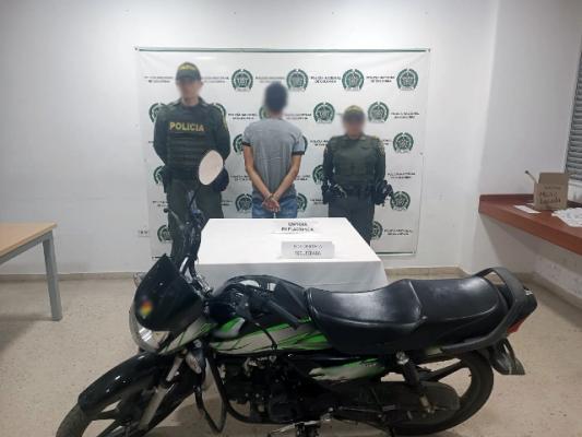 Persona capturada-policías custodiando-motocicleta recuperada