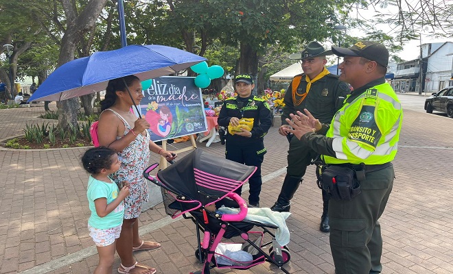 Policía de la seccional de transito y transporte, carabineros e infancia y adolescencia haciendo un saludo una madre en su día 