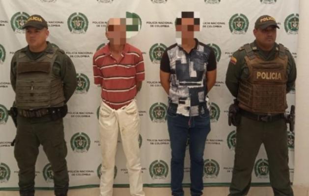 Personas capturadas-policías custodiando