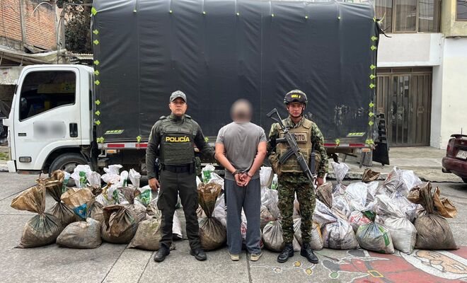 Un hombre capturado con dos polic&iacute;as en cada lado y al fondo el veh&iacute;culo y los insumos incautados 