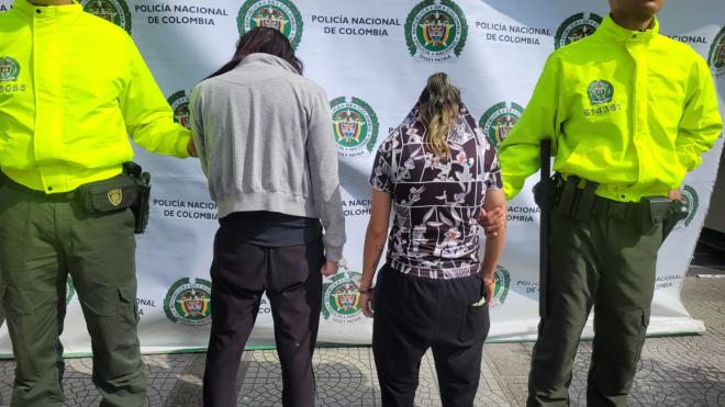 Personas capturadas-policías custodiando