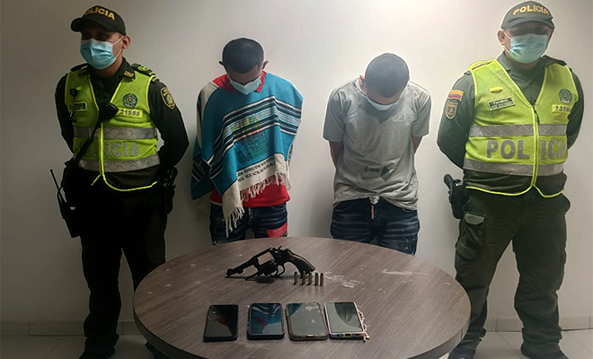 2 personas capturadas-policías custodiando-arma de fuego y munición incautada