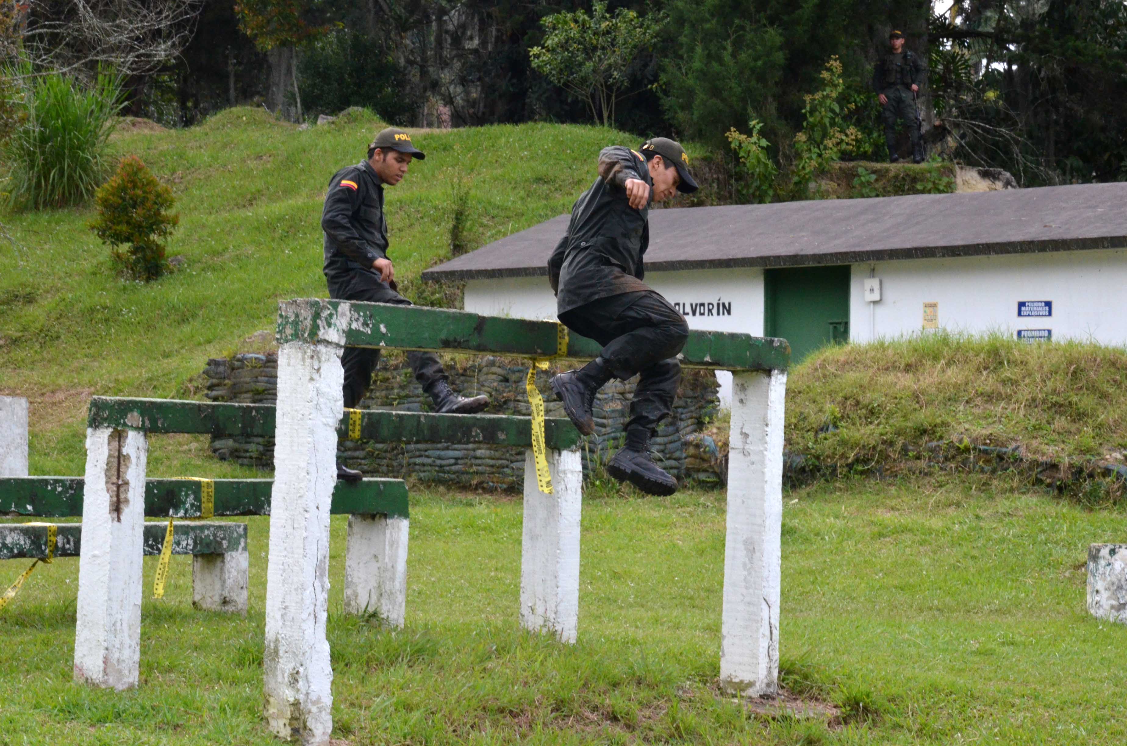 Dos participantes de policía por un día saltan obstaculos