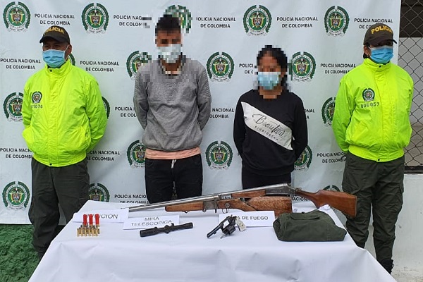 2 personas capturadas-policías custodiando-armas de fuego incautadas