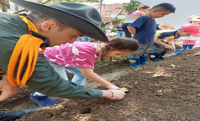 policías compartiendo con niños en huertas escolares 