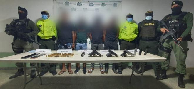 4 personas capturadas-policías custodiando-armas de fuego incautadas