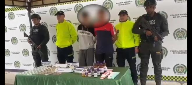 Personas capturadas-policías custodiando