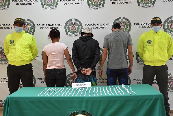 3 personas capturadas-policias custodiando- alucinogenos incautados