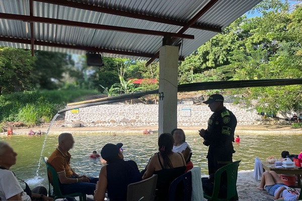 Policía de infancia y adolescencia en centro recreativo compartiendo recomendaciones de seguridad a cinco ciudadanos